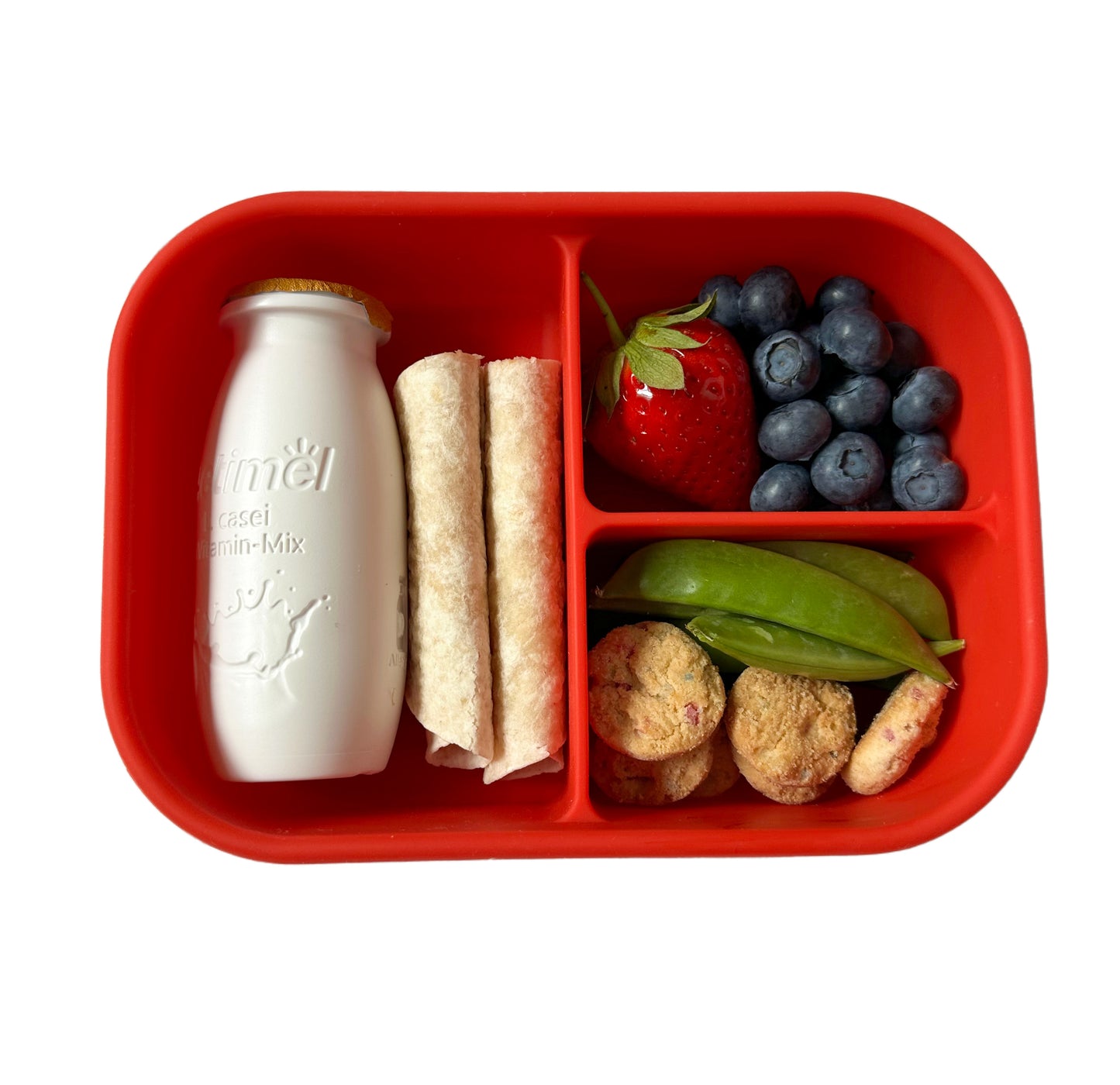red 3 compartment silicone lunchbox filled with a wrap, Actimel drink, blueberries, a strawberry, sugar snap peas and some mini cookies.