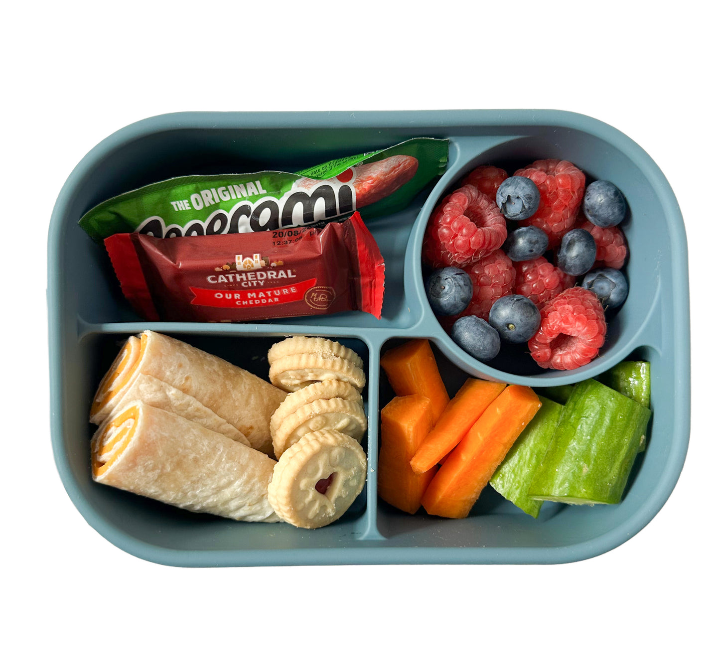 a blue silicone compartment lunchbox filled with a cheese wrap, chopped fruit and veggies, a pepperami and a small cathedral city cheese portion.