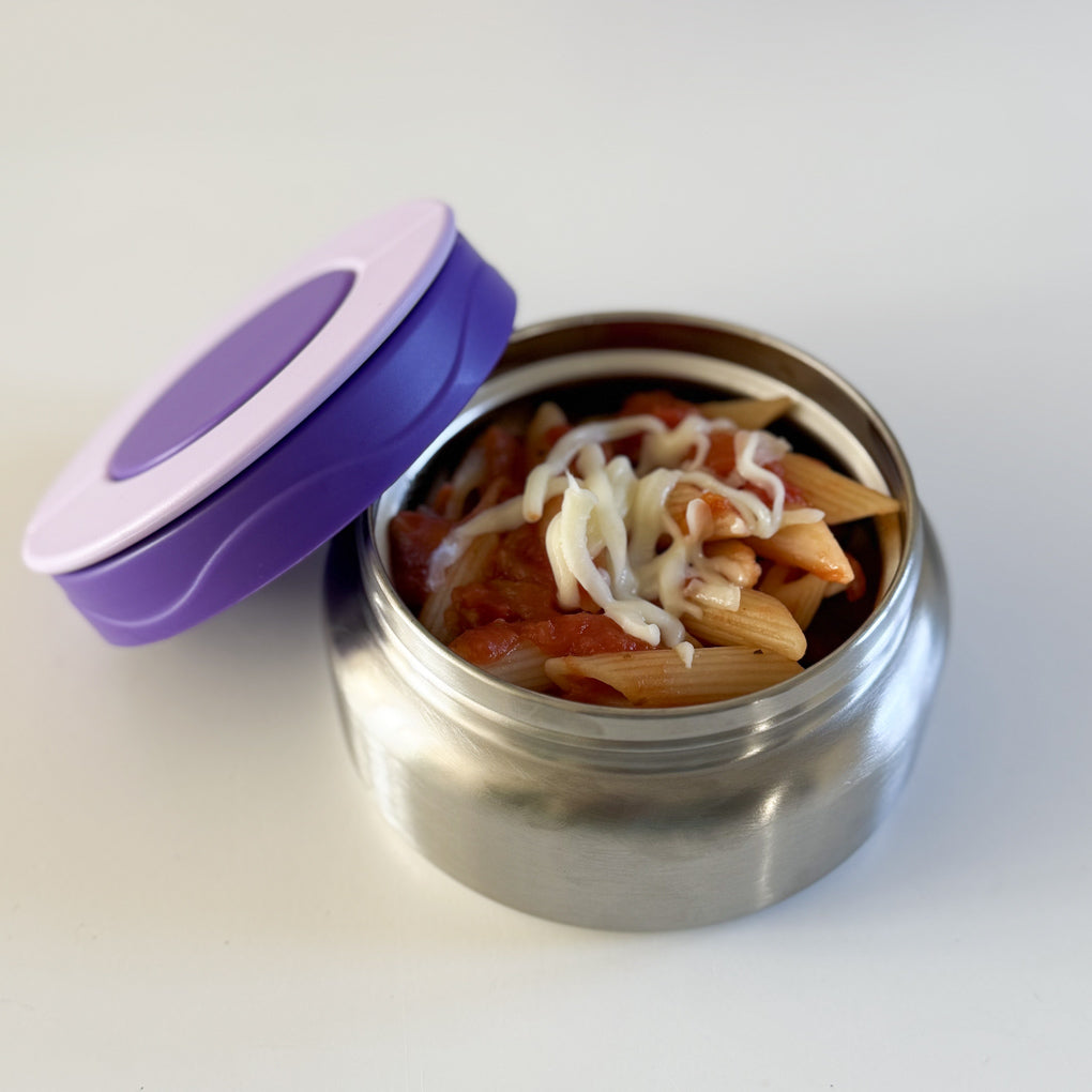 Small stainless steel food thermos with a purple lid containing cooked pasta and grated cheese.