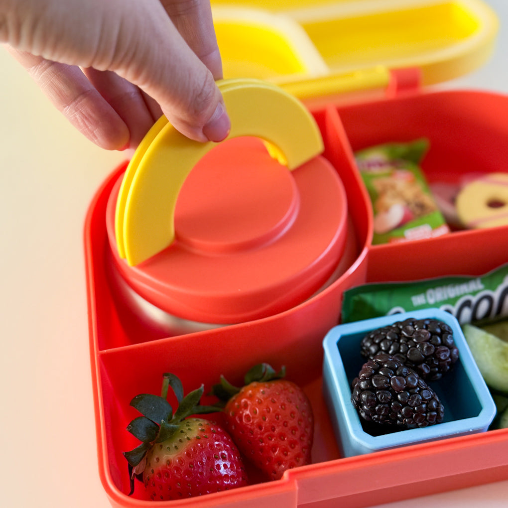 a small orange food flask with flip up handles in a yellow and orange compartment lunchbox