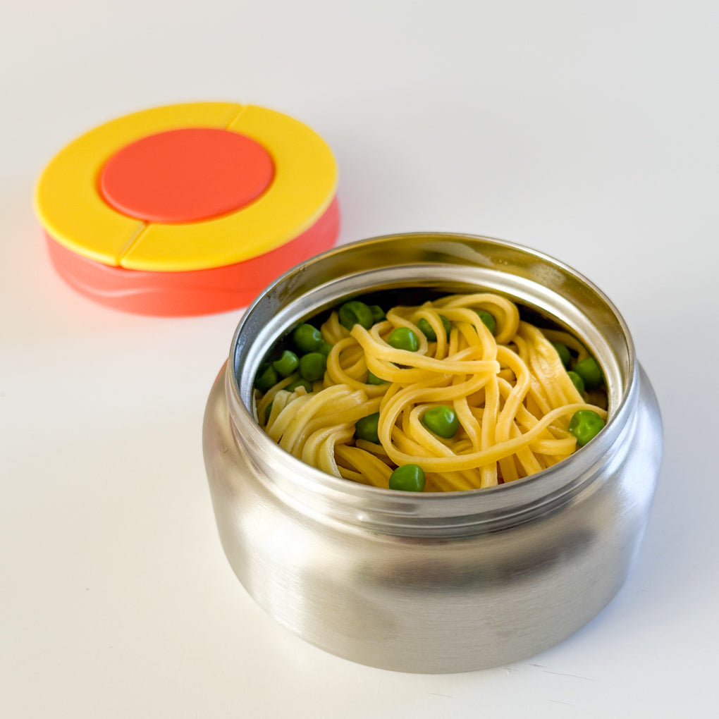 Yellow & Orange stainless steel food thermos with noodles and peas inside.