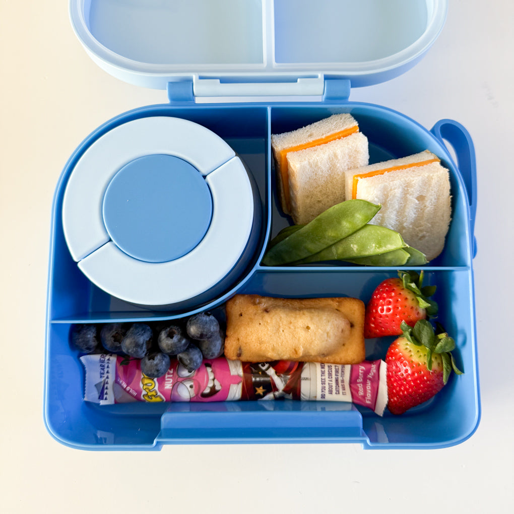 A blue compartment lunchbox with stainless steel food flask packed with a school lunch.