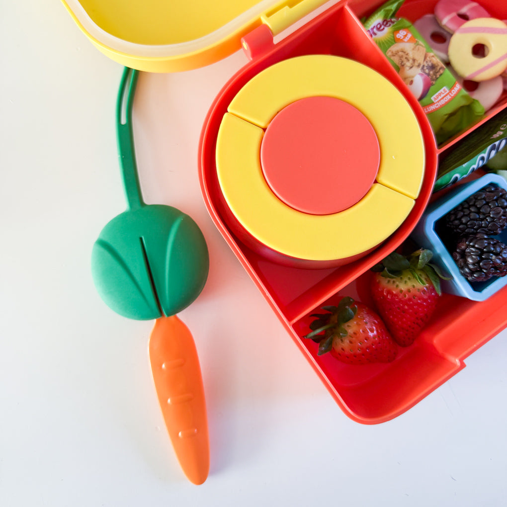 Green and orange lunchbox cutlery next to the Yellow and Orange Pick Box Hot & Cold Lunchbox.