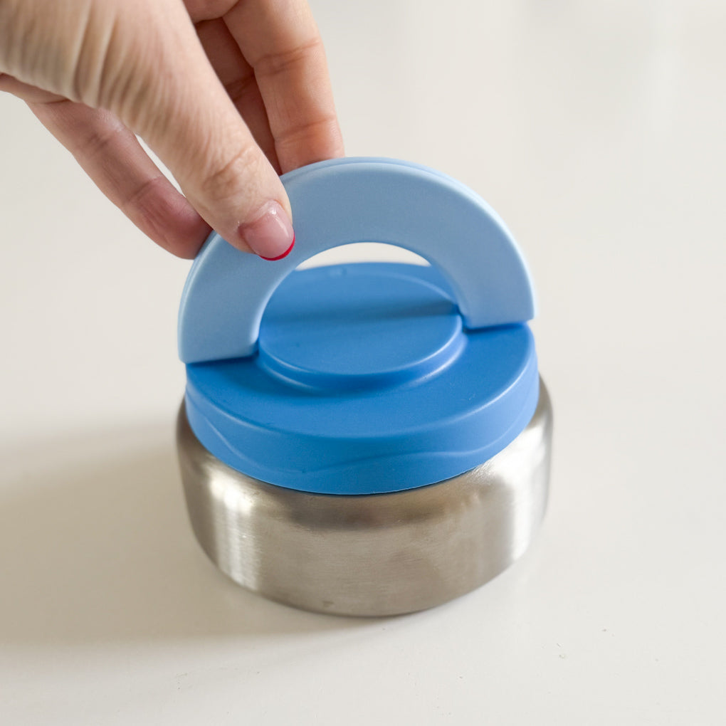 Small stainless steel food thermos with a blue handle for easy opening.