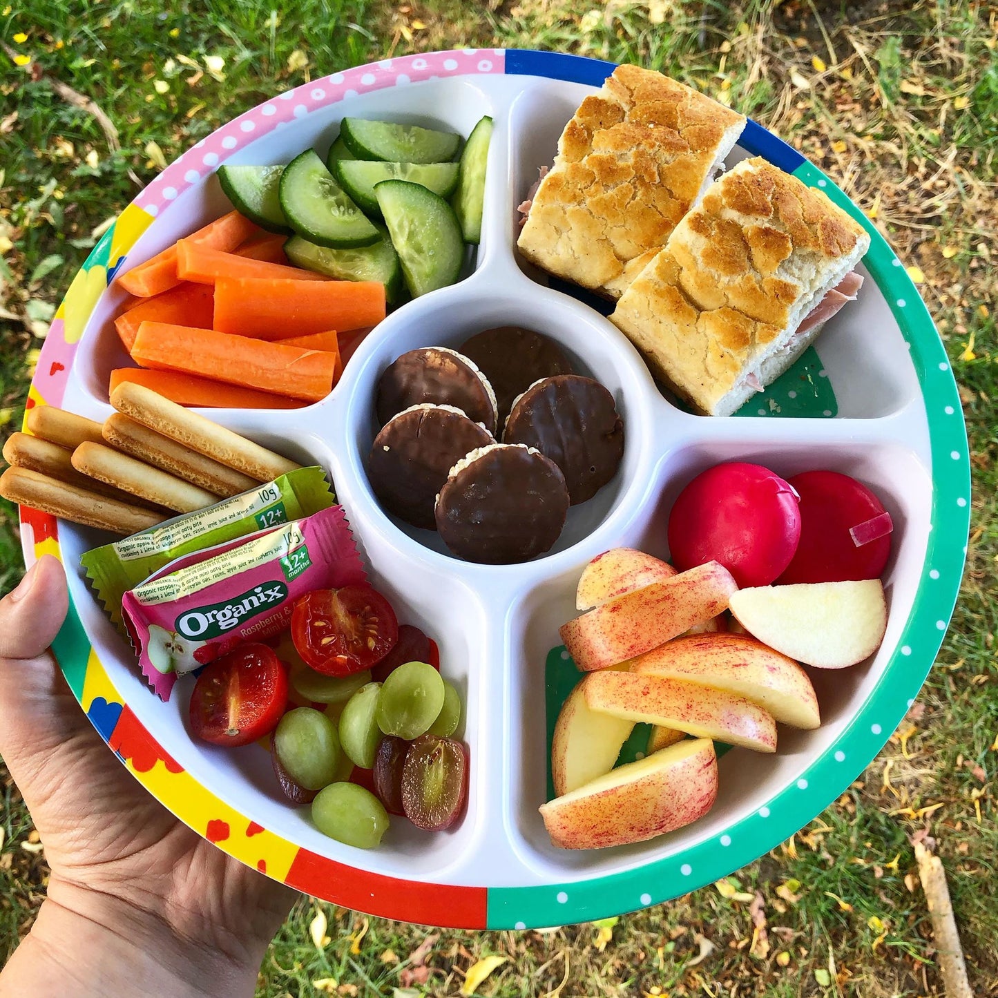 Kids divided sharing plate filled with a variety of snacks.