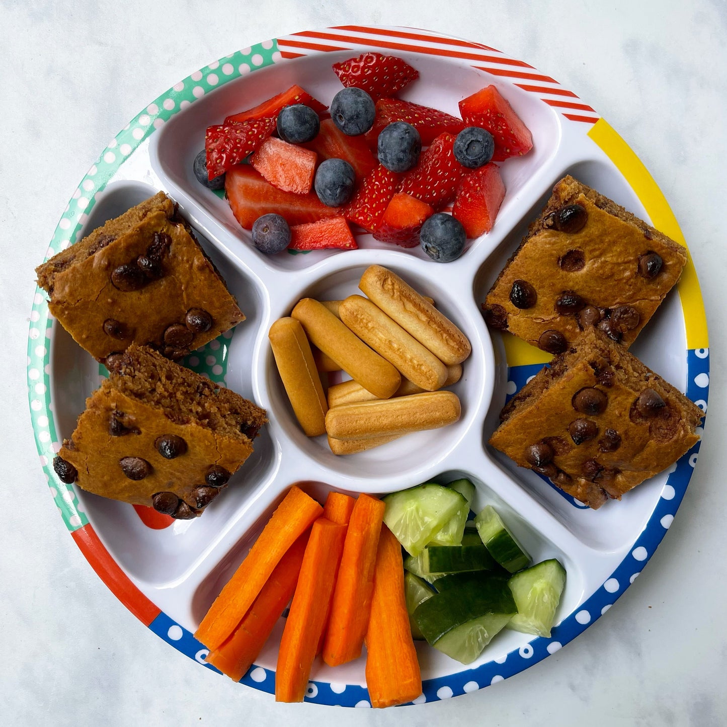 The Pick Plate Midi divided plate shown being used as a sharing snack plate for kids.