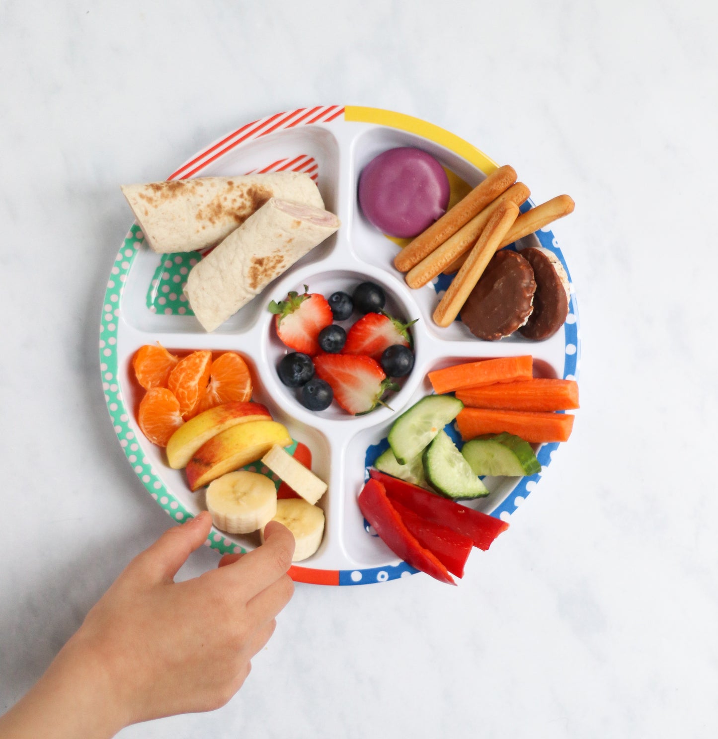 The Pick Plate Midi being used as a fun food plate for fussy eaters with a variety of healthy snacks in the divided compartments.