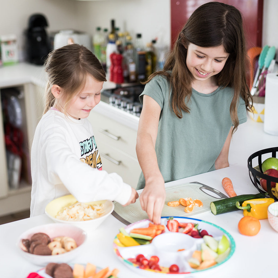 Two children preparing snacks to fill the Pick Plate Biggie.
