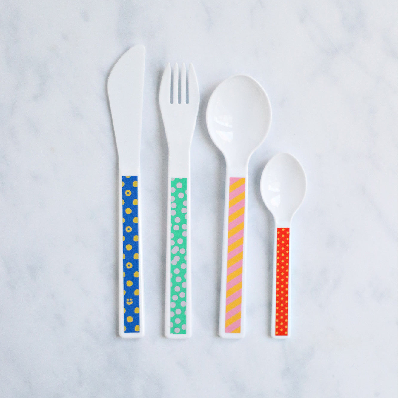 Kids multi-coloured cutlery set containing a fork, knife, spoon and tea spoon.